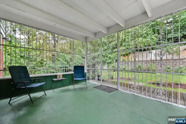 a building outdoor space with seating area and trees in the background