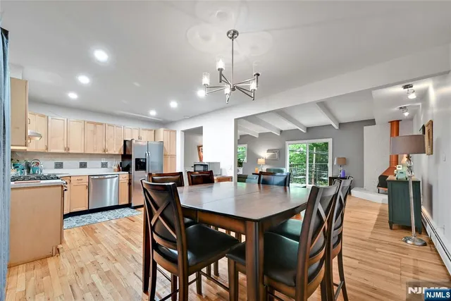 a view of a dining room and livingroom with furniture wooden floor a chandelier