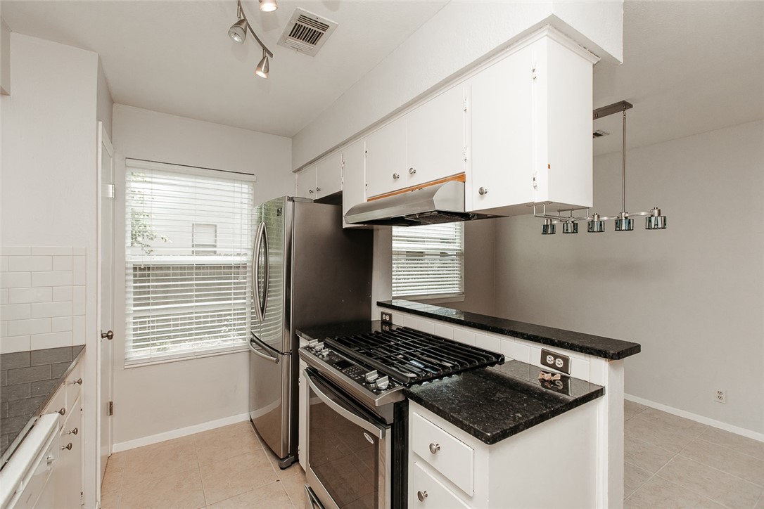 1012 Milford Way Austin, TX 78745 - Photo 4 of 21 a kitchen with granite countertop a sink stove and refrigerator