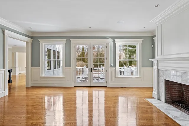 wooden floor fireplace and windows in an empty room