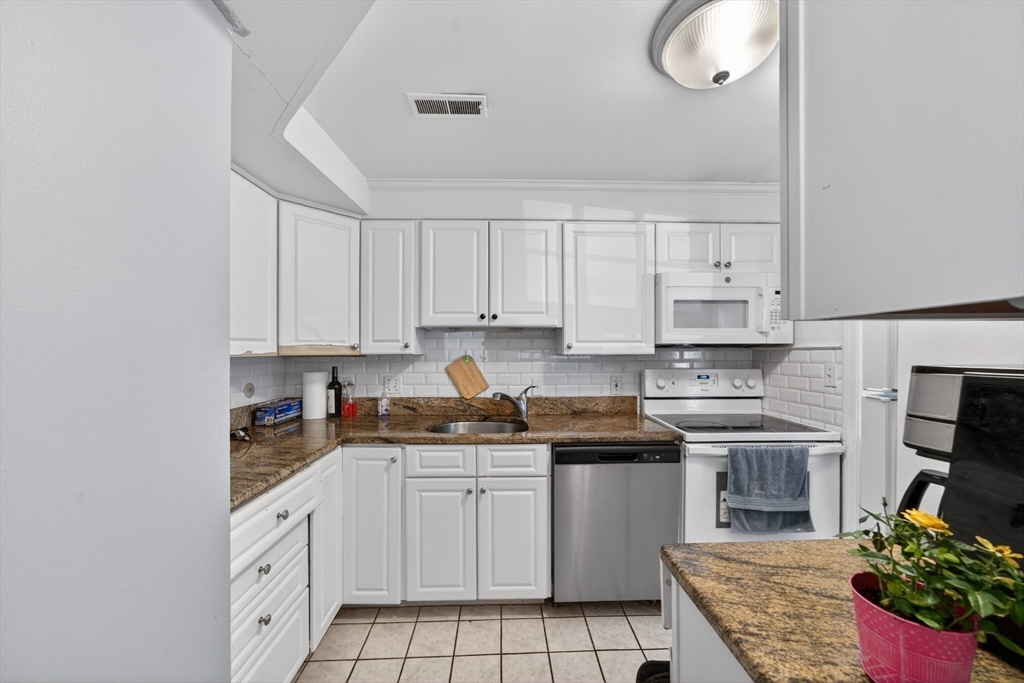 68 Jericho Road, Unit 68 Weston, MA 02493 - Photo 3 of 25 a kitchen with white cabinets stainless steel appliances and sink