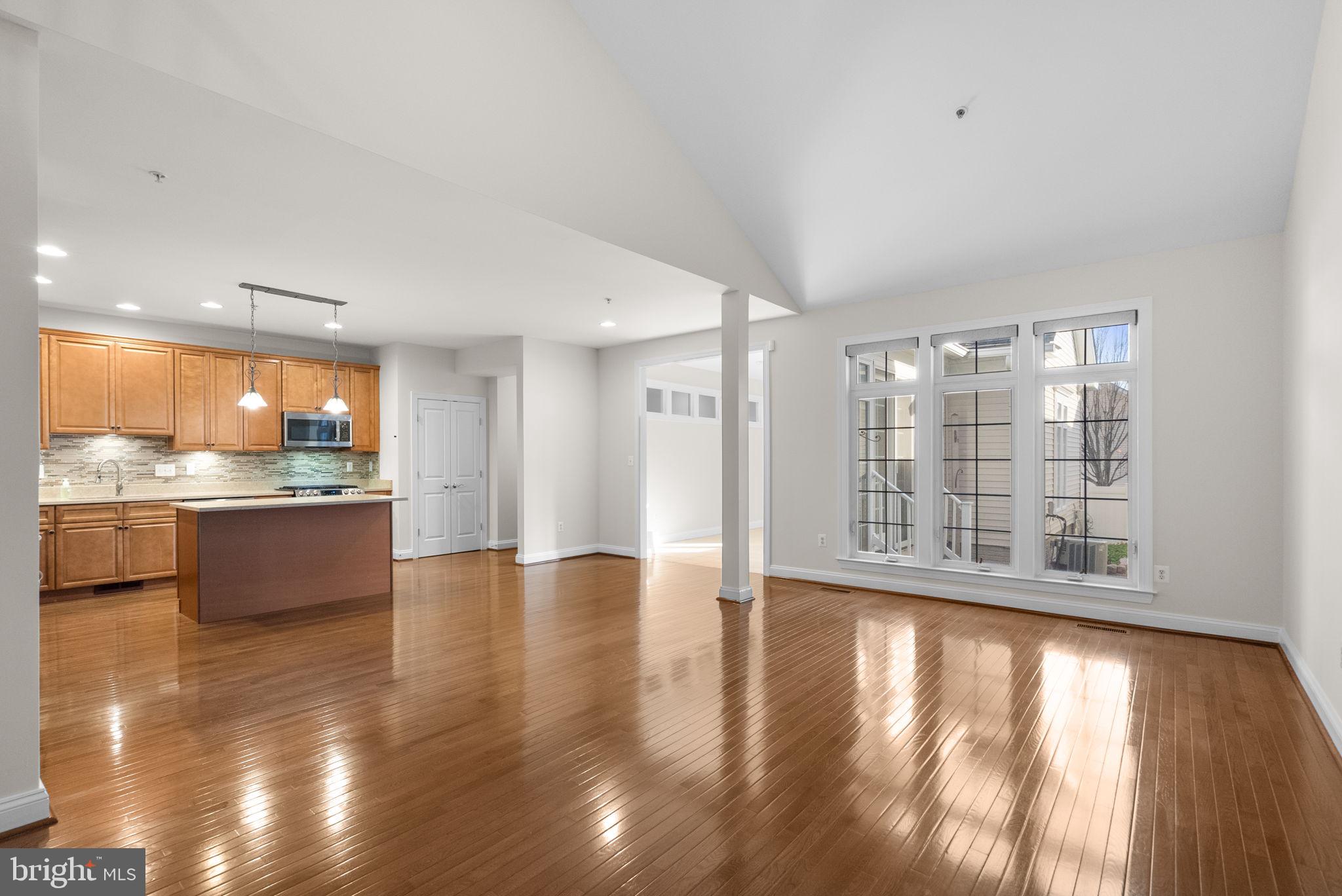 2788 Westminster Road Ellicott City, MD 21043 - Photo 71 of 75 a view of an empty room with wooden floor and a kitchen