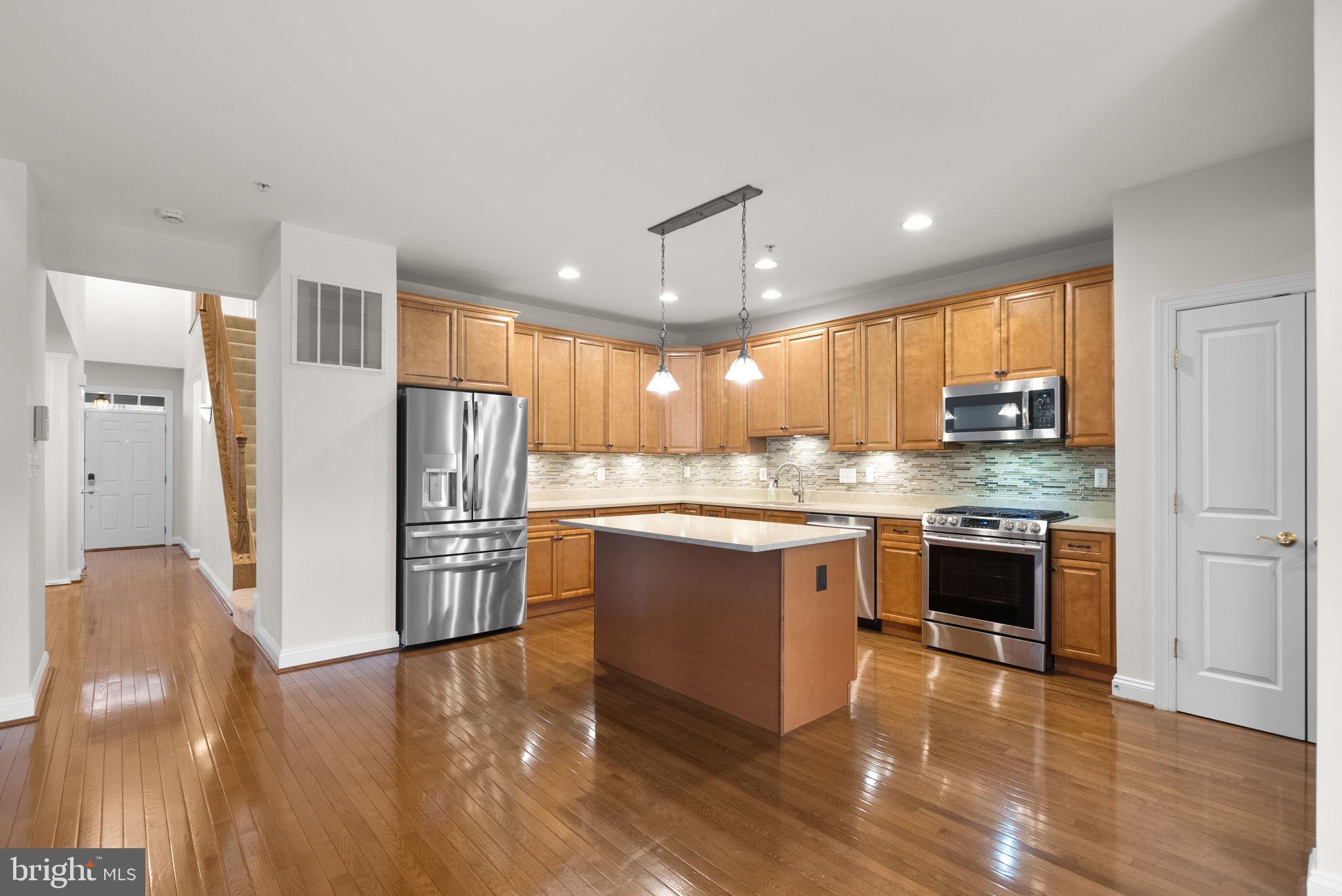 2788 Westminster Road Ellicott City, MD 21043 - Photo 4 of 75 a kitchen with stainless steel appliances granite countertop a refrigerator a sink dishwasher a stove and white countertops with wooden floor