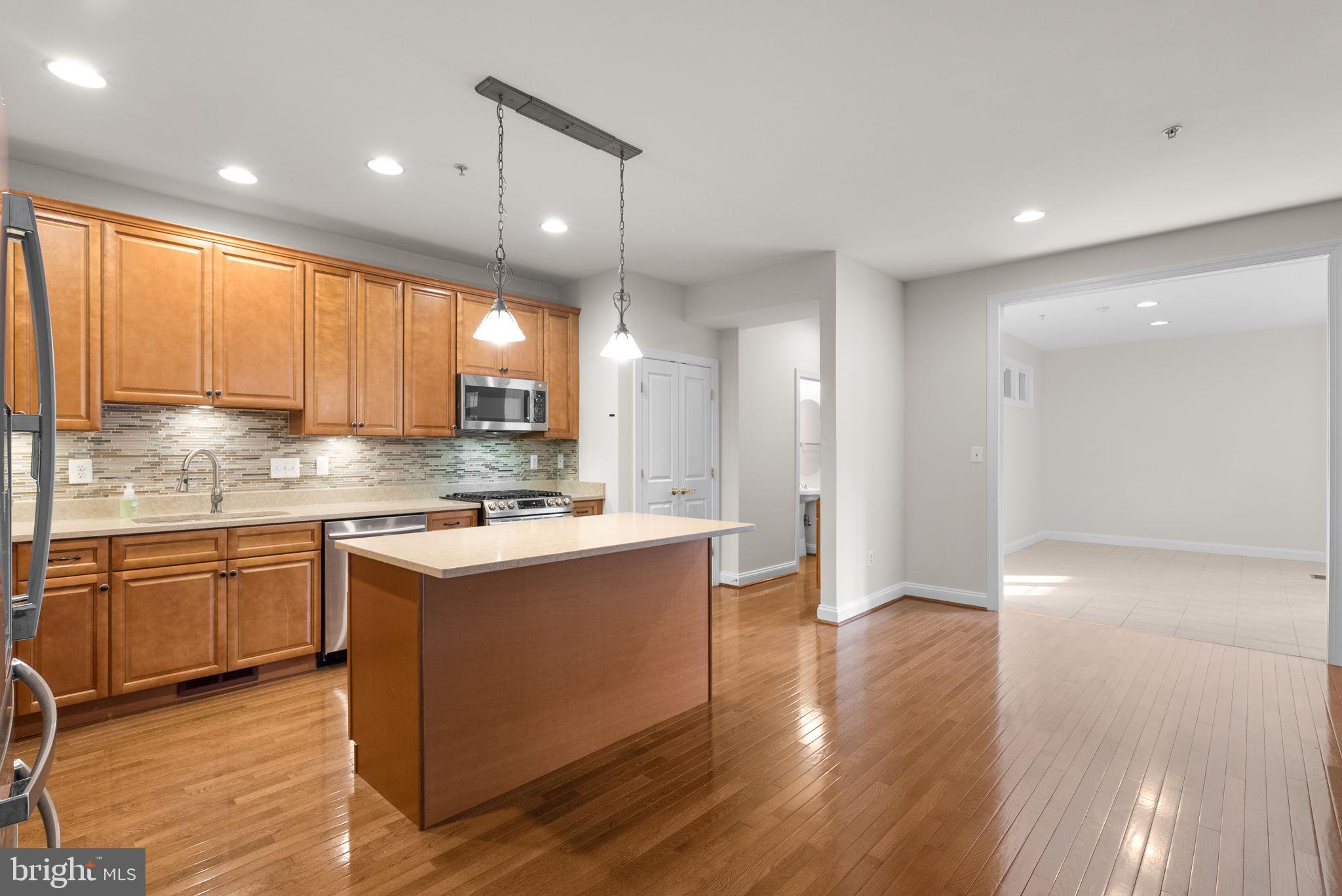 2788 Westminster Road Ellicott City, MD 21043 - Photo 7 of 75 a kitchen with kitchen island granite countertop a sink cabinets and wooden floor