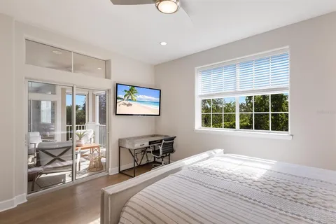 a bedroom with a bed and a large window with chair