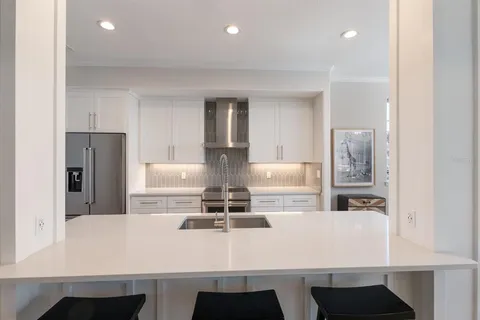 a kitchen with kitchen island white cabinets and refrigerator