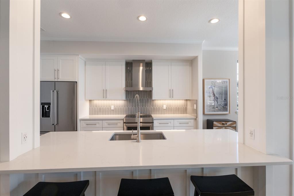 8035 St Simons Street, Unit 8035 University Park, FL 34201 - Photo 4 of 33 a kitchen with kitchen island white cabinets and refrigerator