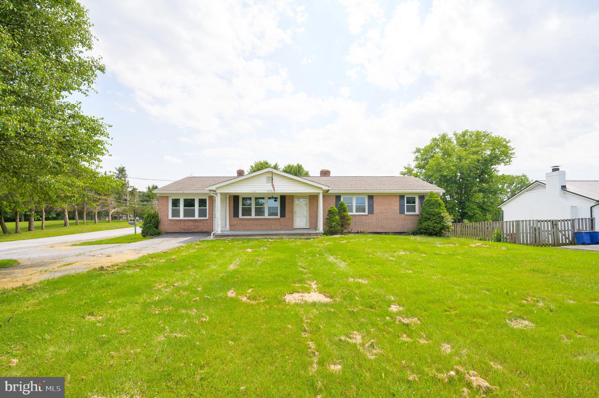 a front view of a house with yard and green space
