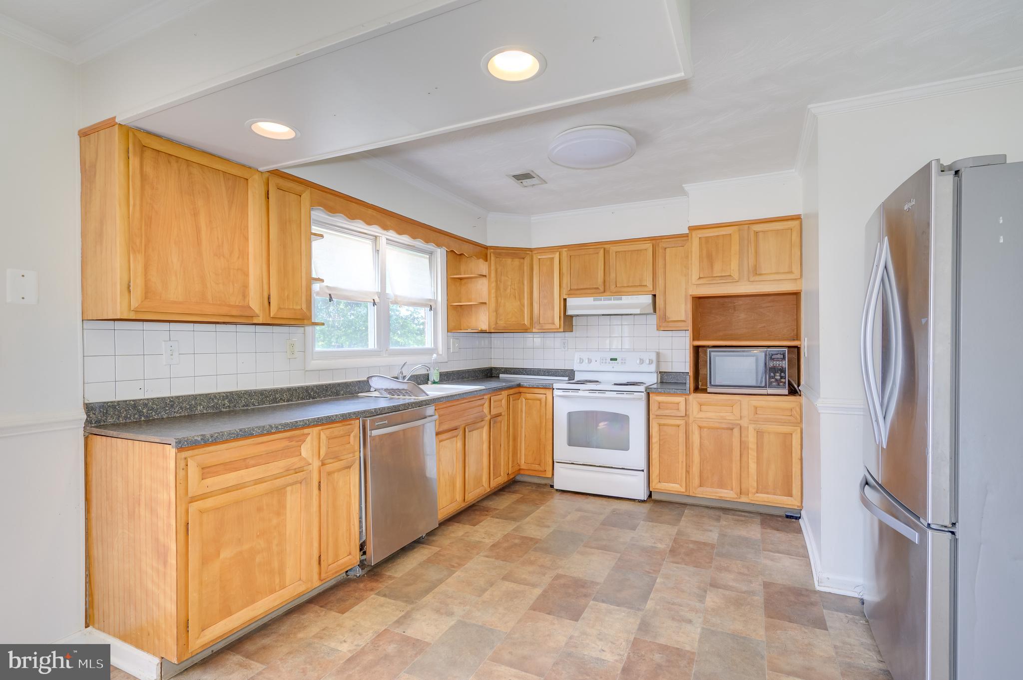 3208 Old Leetown Pike Ranson, WV 25438 - Photo 13 of 48 a kitchen with granite countertop a refrigerator a sink a stove a dining table and chairs