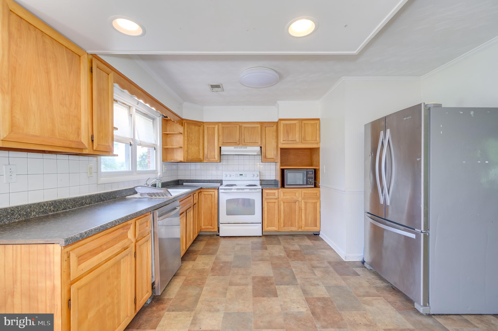 3208 Old Leetown Pike Ranson, WV 25438 - Photo 14 of 48 a large kitchen with stainless steel appliances granite countertop a refrigerator and a sink