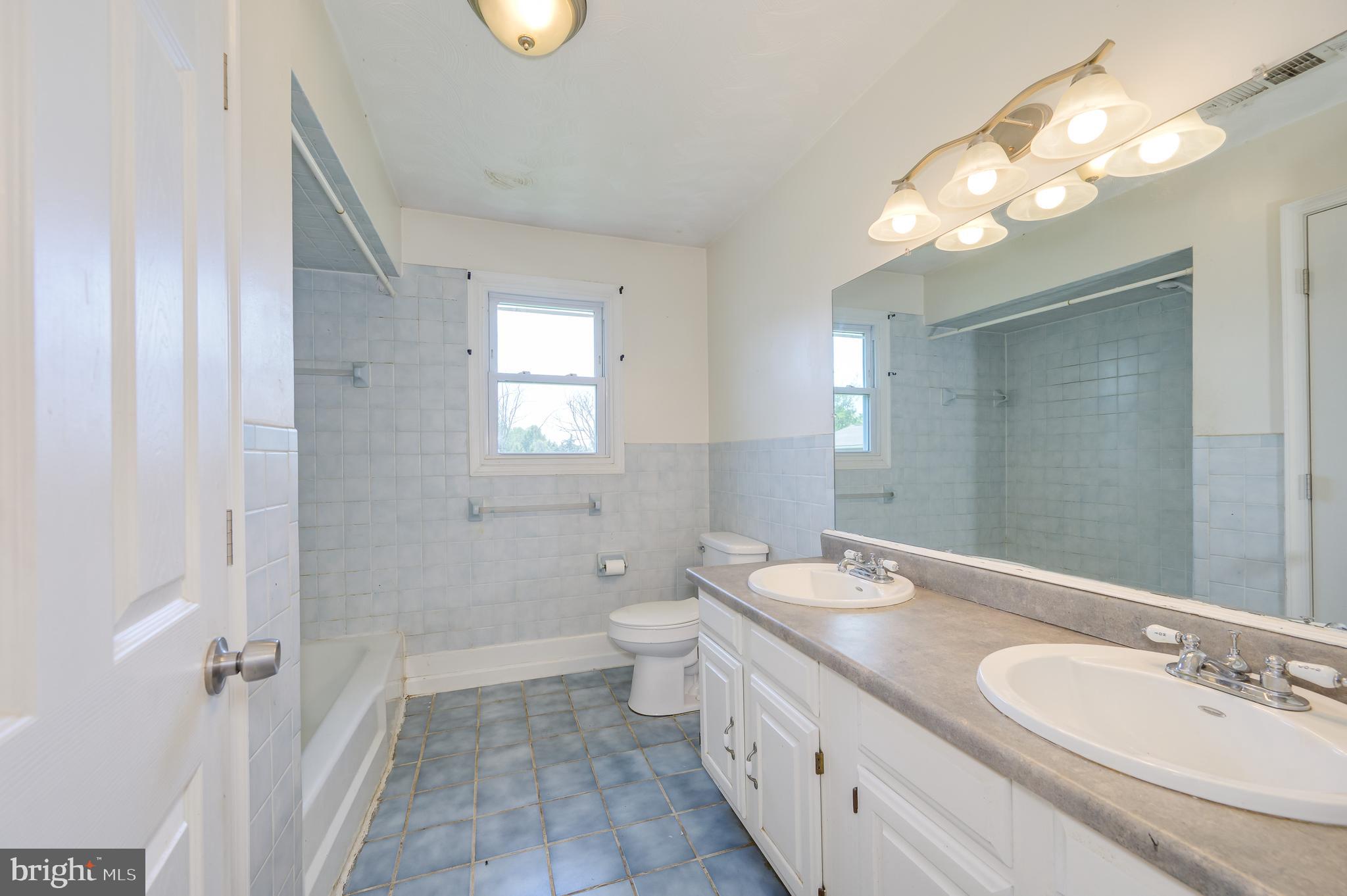 3208 Old Leetown Pike Ranson, WV 25438 - Photo 22 of 48 a bathroom with a granite countertop double vanity sink a toilet and a mirror