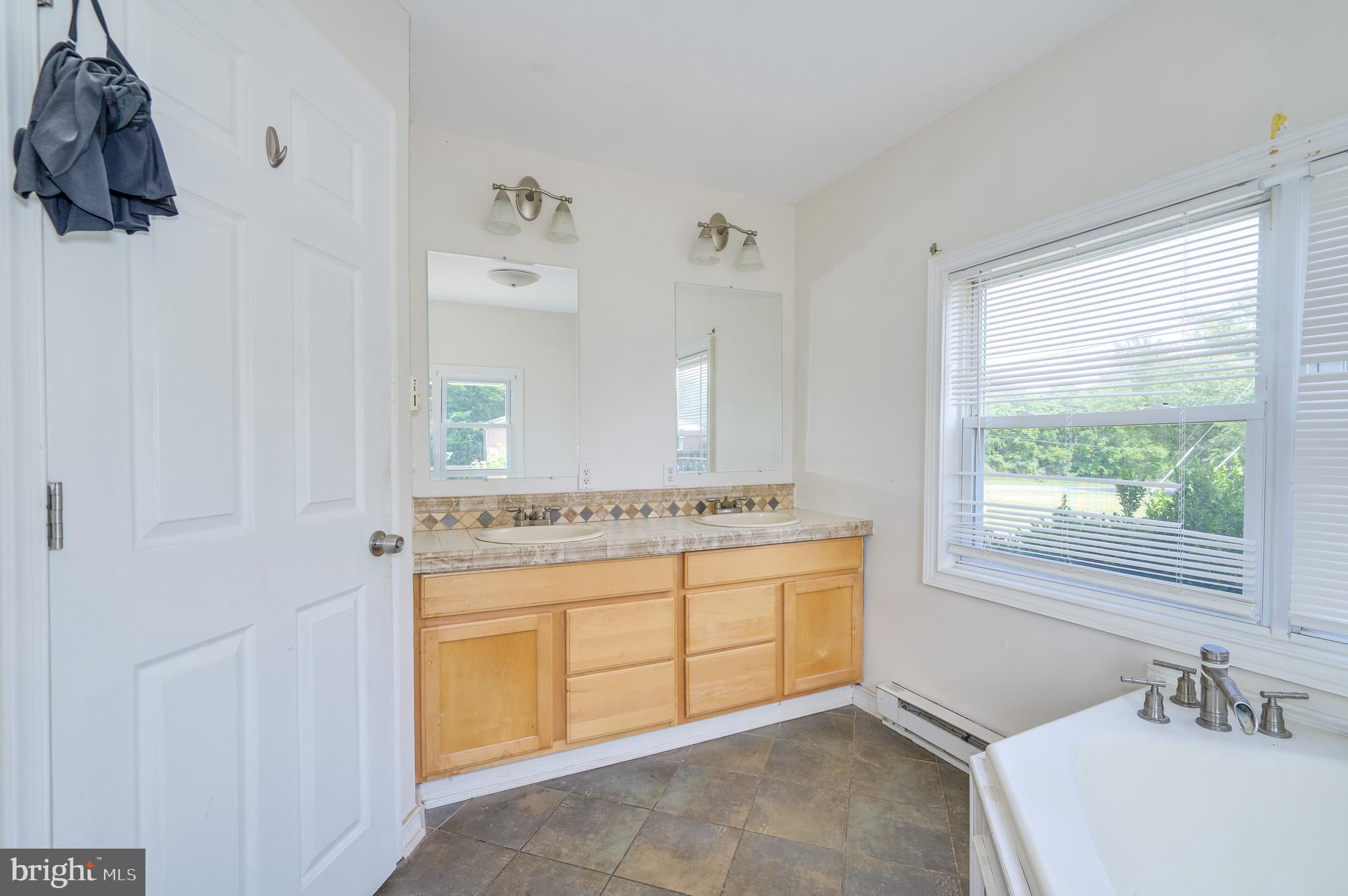 3208 Old Leetown Pike Ranson, WV 25438 - Photo 28 of 48 a bathroom with a granite countertop sink a mirror and a bathtub