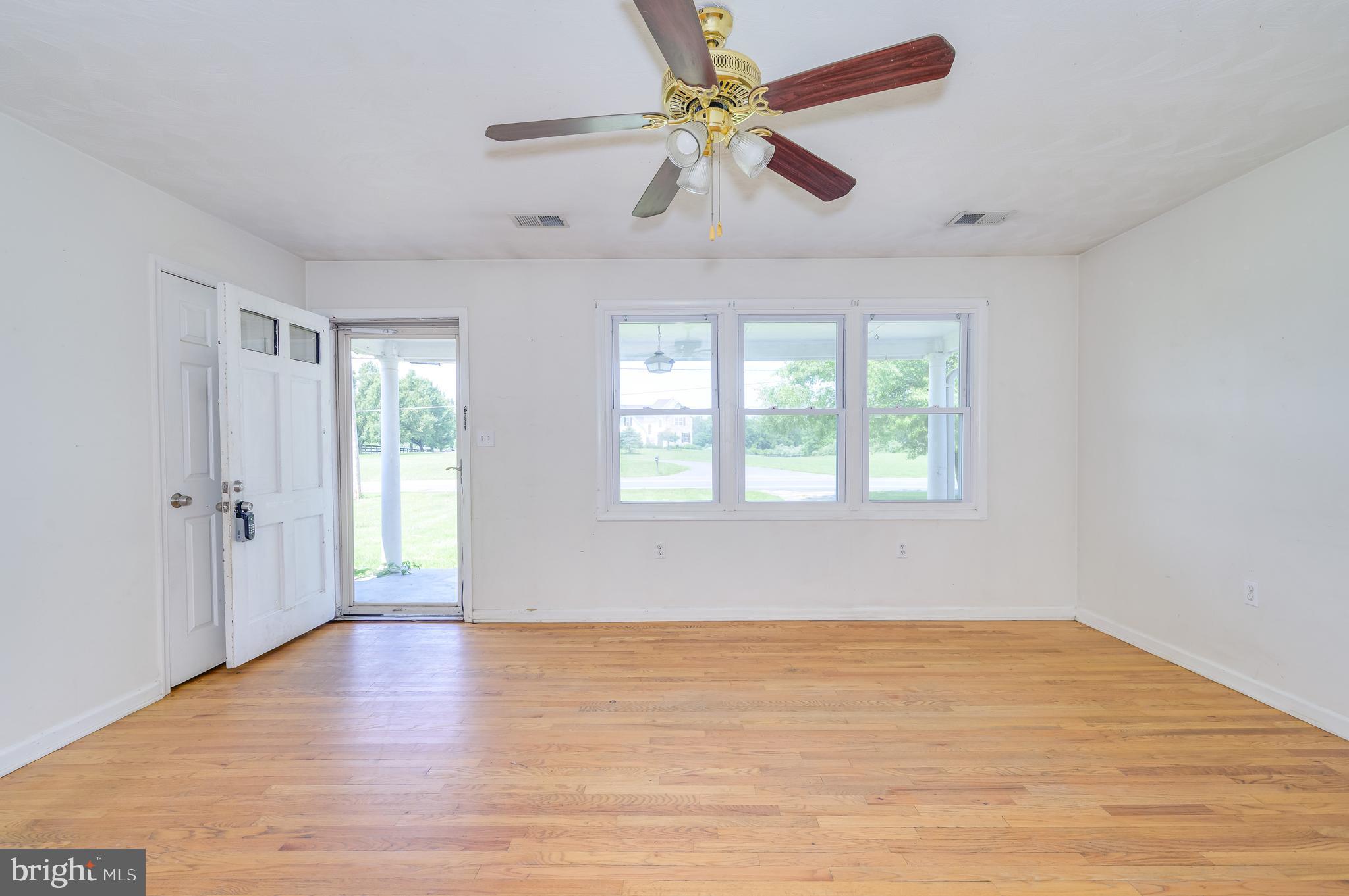 3208 Old Leetown Pike Ranson, WV 25438 - Photo 9 of 48 an empty room with wooden floor fan and windows