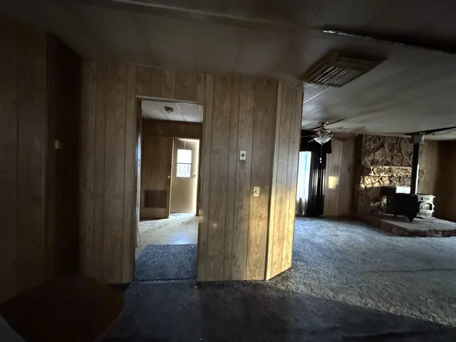 a backyard of a house with large trees and wooden fence