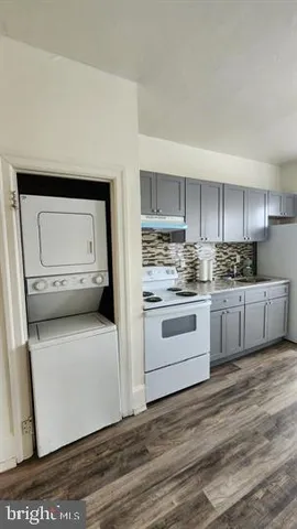 a kitchen with stainless steel appliances granite countertop a stove a sink and white cabinets