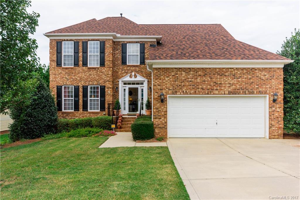a front view of a house with yard and garage
