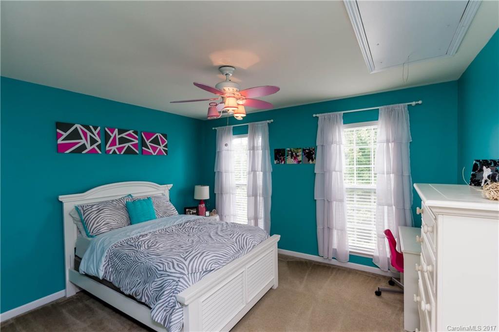 5556 Alexandrite Way Fort Mill, SC 29708 - Photo 12 of 20 a bedroom with a bed and a chandelier