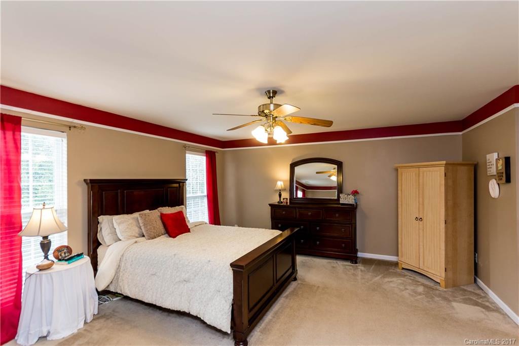 5556 Alexandrite Way Fort Mill, SC 29708 - Photo 13 of 20 a bedroom with a bed and a chandelier