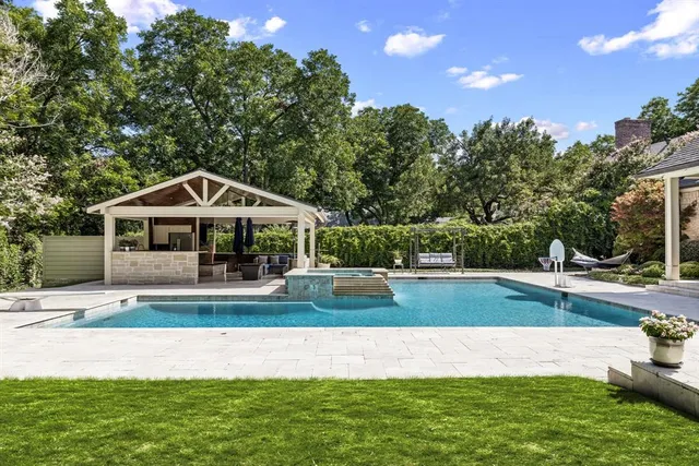 a front view of house with yard and trees in the background