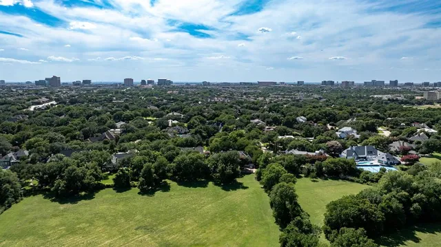 an aerial view of residential houses with outdoor space and trees