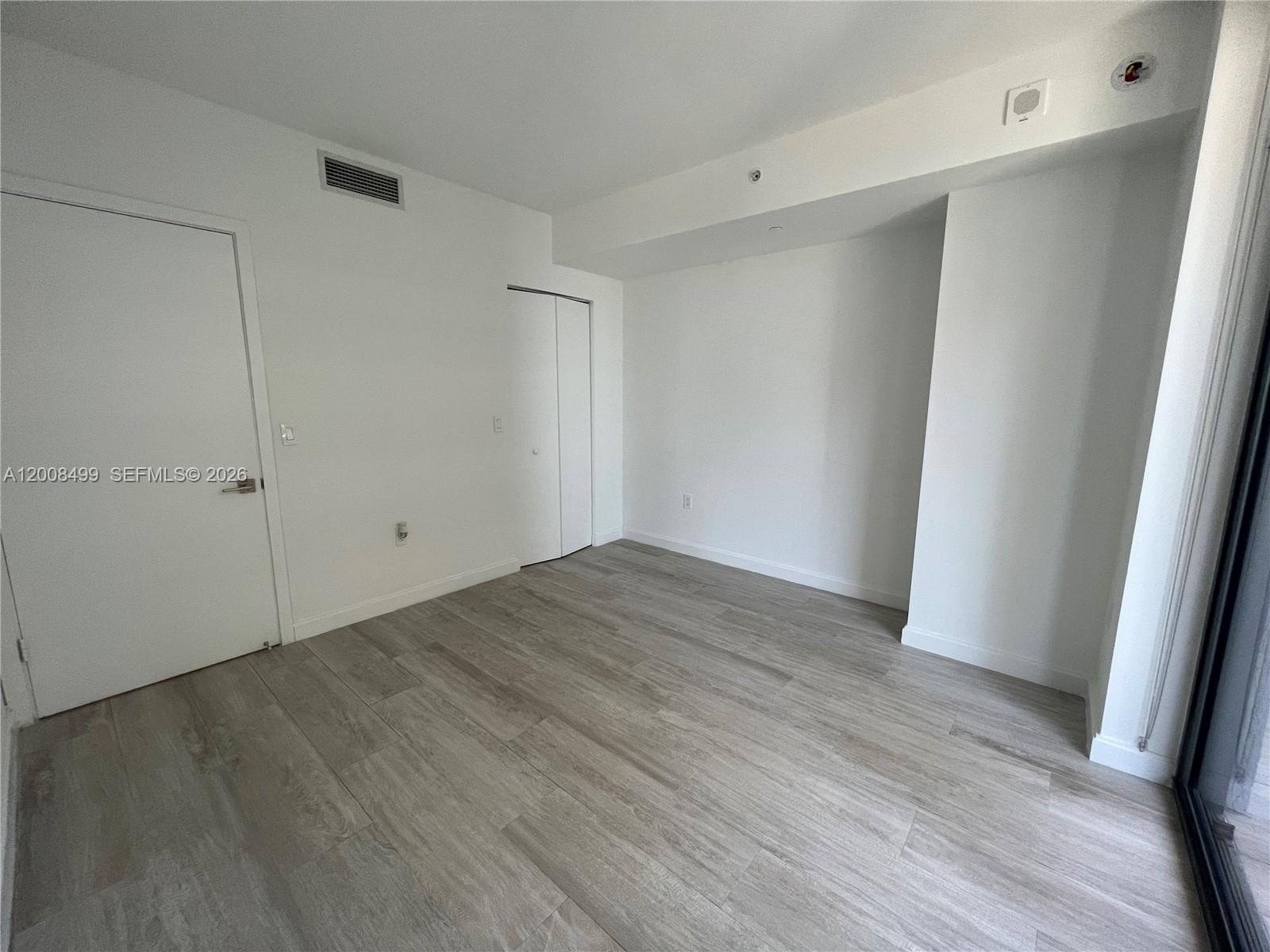 55 Southwest 9th Street, Unit 2702 Miami, FL 33130 - Photo 14 of 36 a view of empty room with wooden floor