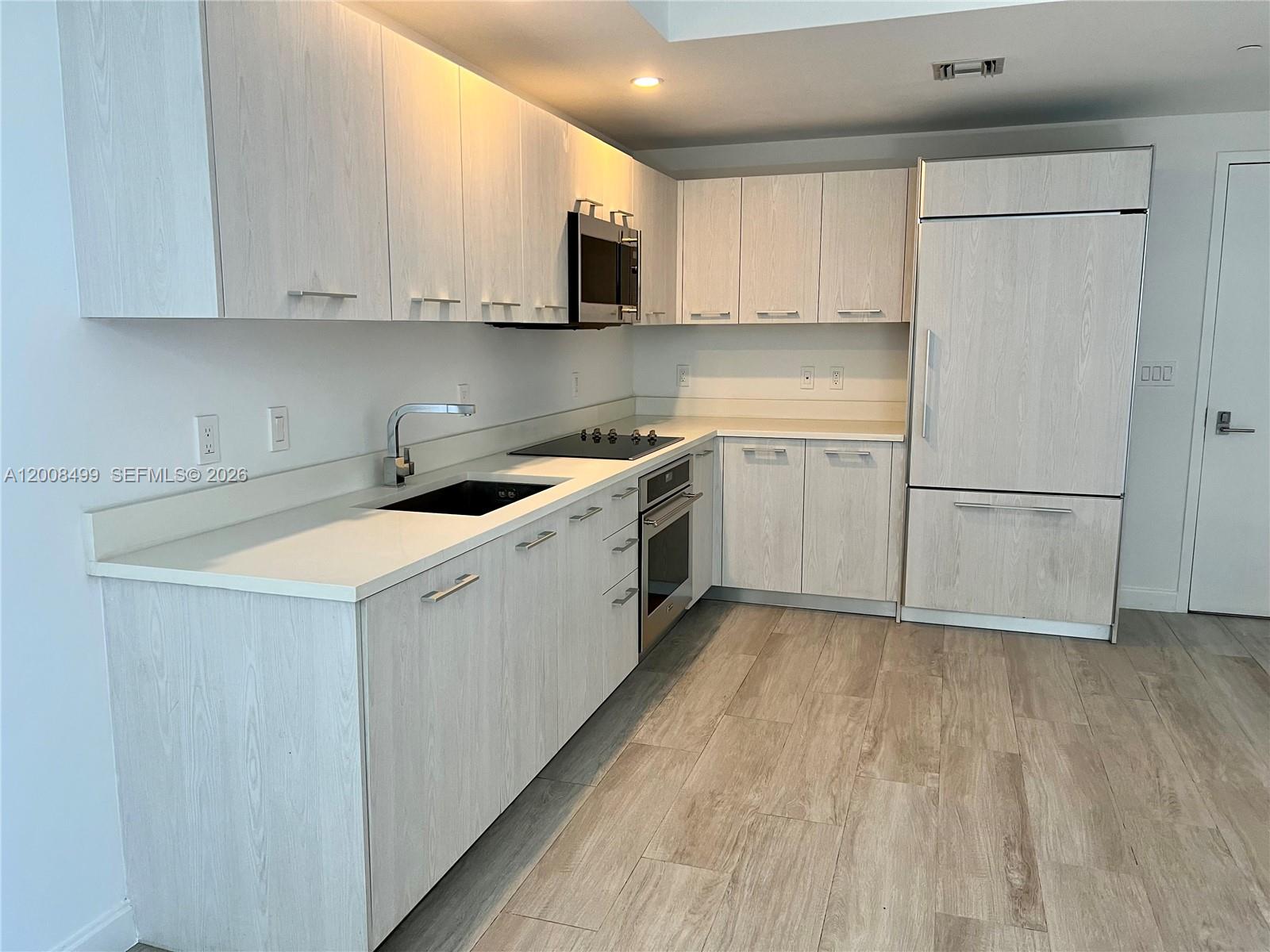 55 Southwest 9th Street, Unit 2702 Miami, FL 33130 - Photo 5 of 36 a kitchen with a sink a stove and cabinets