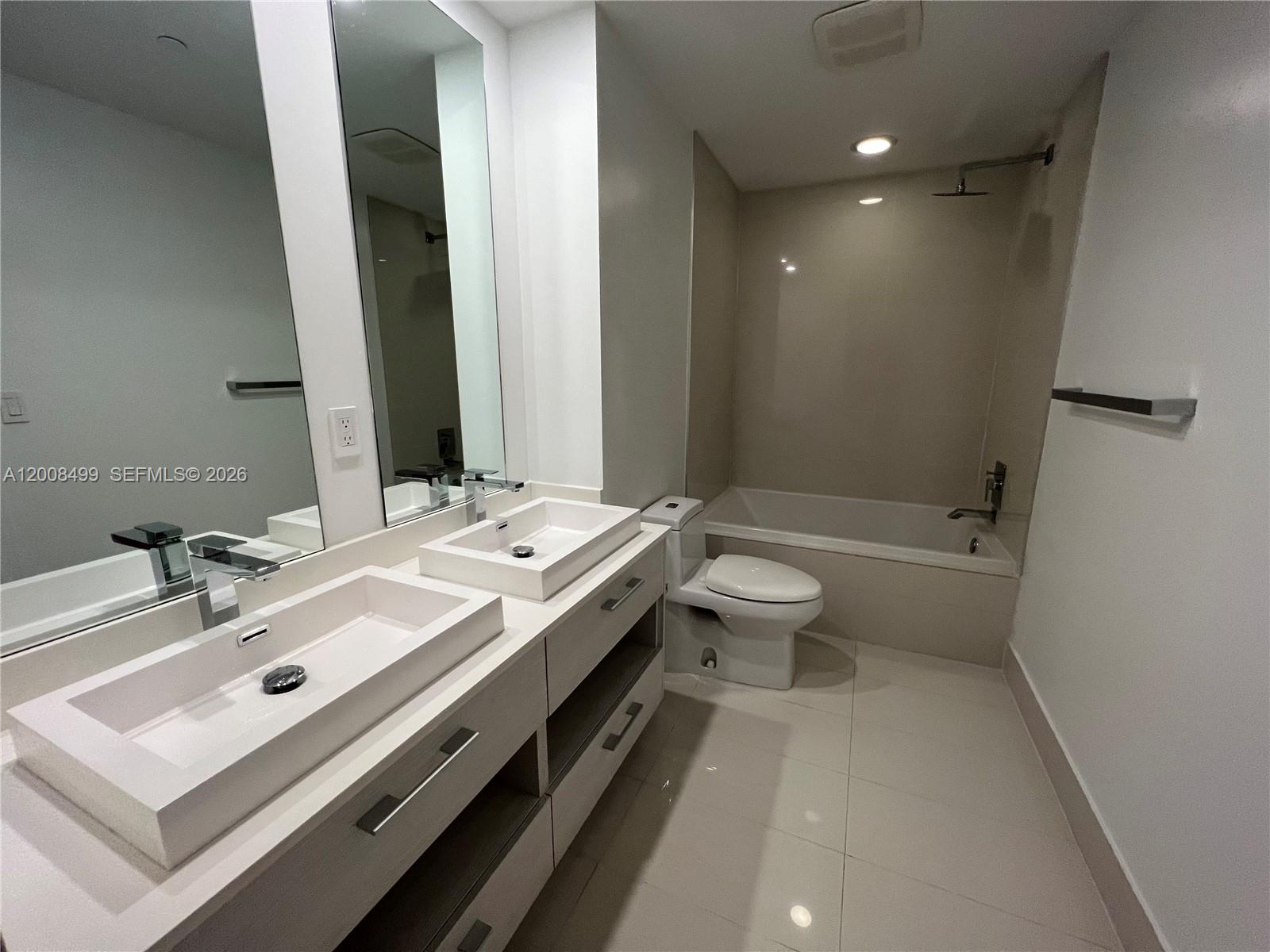55 Southwest 9th Street, Unit 2702 Miami, FL 33130 - Photo 8 of 36 a bathroom with a double vanity sink toilet and shower