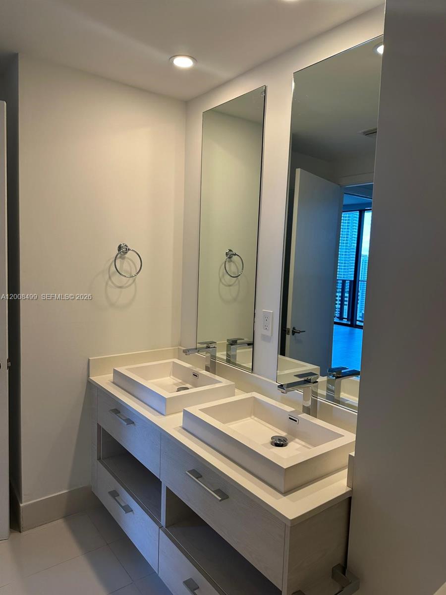 55 Southwest 9th Street, Unit 2702 Miami, FL 33130 - Photo 9 of 36 a bathroom with a sink and a mirror