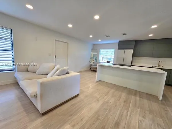 a living room with furniture and a wooden floor