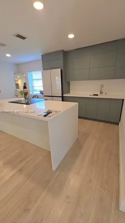 a view of a kitchen with a sink and a dishwasher with wooden floor