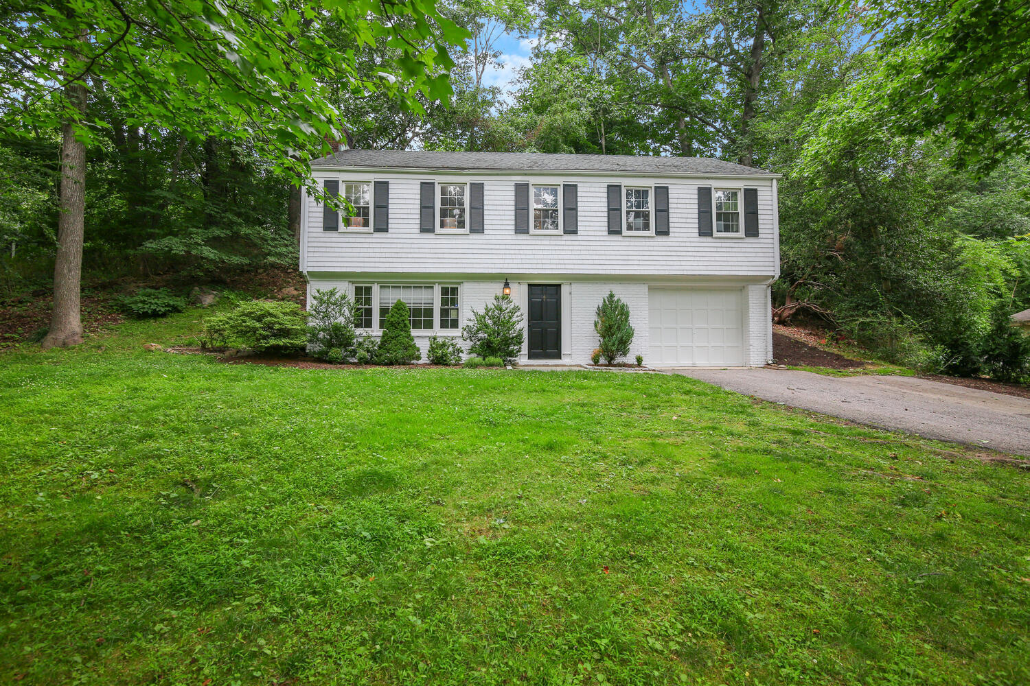 210 Tokeneke Road Darien, CT 06820 - Photo 2 of 24 a front view of a house with a garden