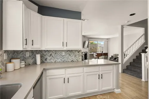a kitchen with white cabinets and sink