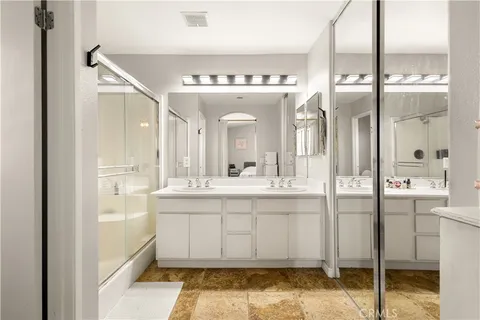 a bathroom with a double vanity sink and a mirror