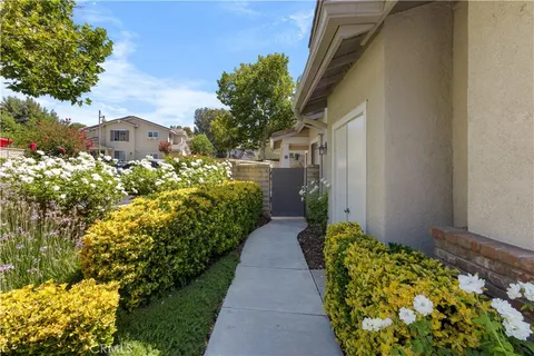 a view of a pathway with a flower garden