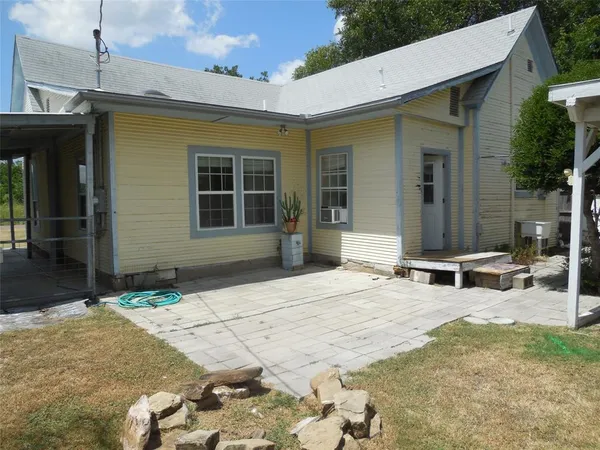 a view of a house with backyard and sitting area