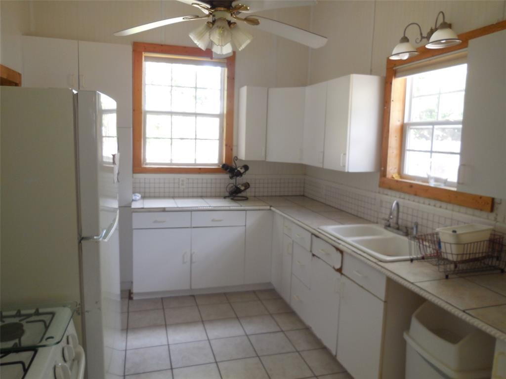 316 Mesquite Street Ranger, TX 76470 - Photo 9 of 21 a kitchen with a sink cabinets and window