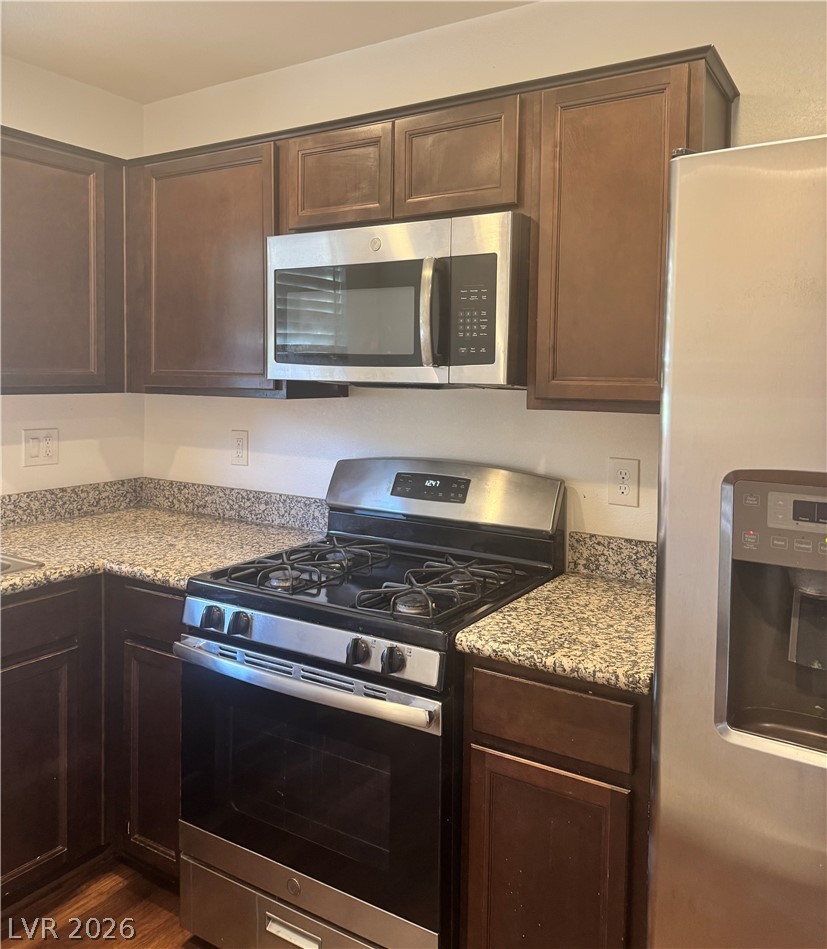 1892 Via Del Rey Court Las Vegas, NV 89115 - Photo 2 of 10 A well-appointed kitchen showcasing dark wood cabinetry and speckled granite countertops.