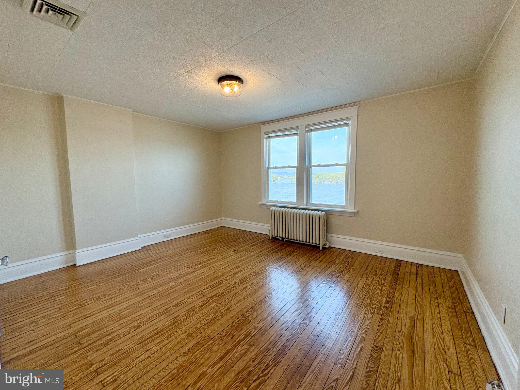 616 North Front Street Wormleysburg, PA 17043 - Photo 23 of 25 an empty room with wooden floor and windows