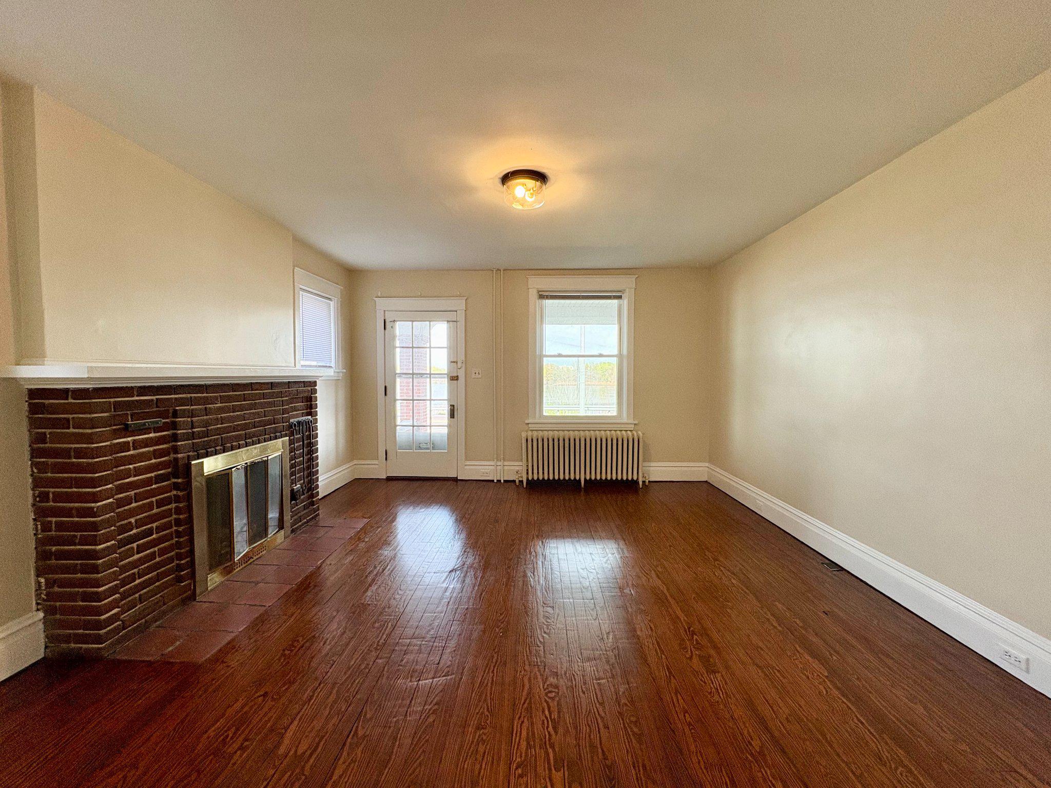 616 North Front Street Wormleysburg, PA 17043 - Photo 8 of 25 an empty room with wooden floor fireplace and windows