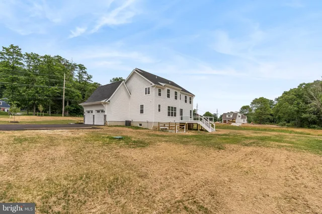 a view of a house with a big yard and large trees