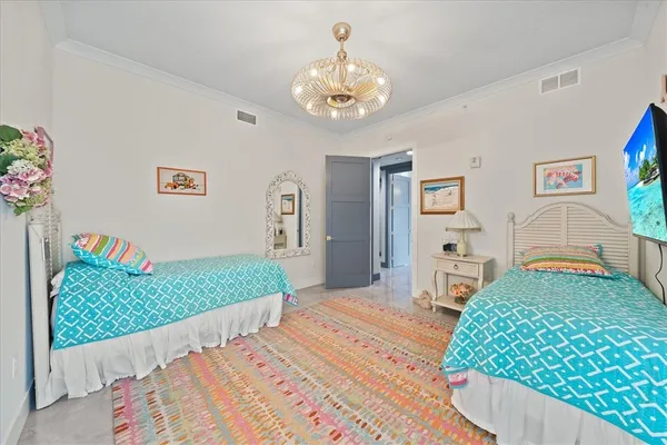 a bedroom with a bed and a chandelier