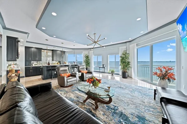 a living room with furniture kitchen view and a large window