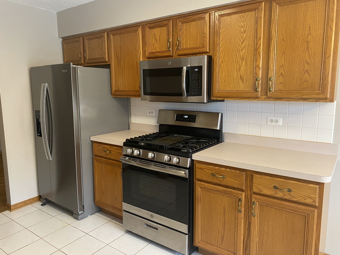 6820 Ridge Point Drive, Unit 21A Oak Forest, IL 60452 - Photo 5 of 16 a kitchen with stainless steel appliances granite countertop a stove microwave and refrigerator