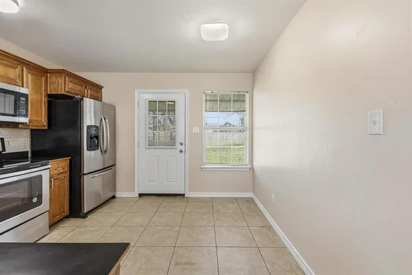 a kitchen with a refrigerator and a stove top oven