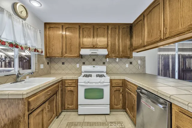 a kitchen with stainless steel appliances granite countertop a refrigerator and a stove