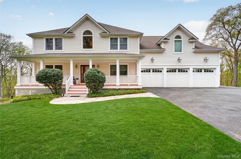 a front view of a house with a yard and trees