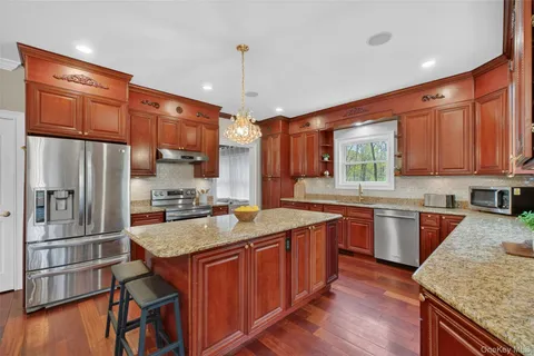 a kitchen with granite countertop a sink a counter top space appliances and cabinets