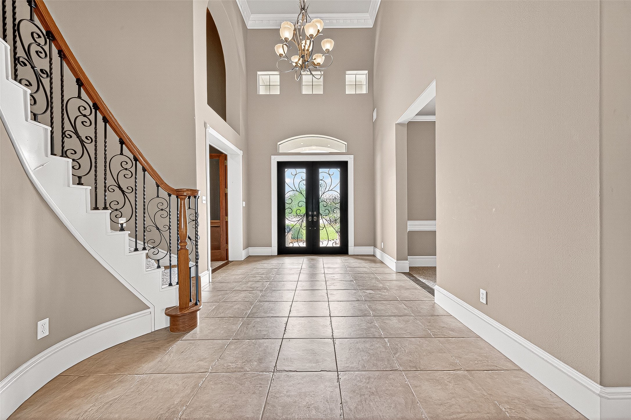 25626 Windy Isle Court Spring, TX 77389 - Photo 4 of 45 Welcome in. You'll find an elegant entryway with high ceilings, and a decorative chandelier, and a striking front door with intricate glasswork, offering a welcoming and sophisticated first impression.