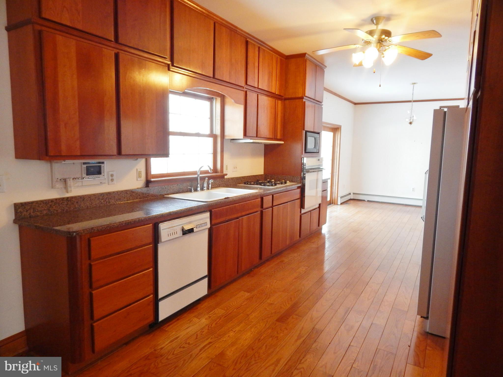 3964 Street Road Street, MD 21154 - Photo 13 of 29 a kitchen with stainless steel appliances granite countertop a sink a stove cabinets and wooden floor