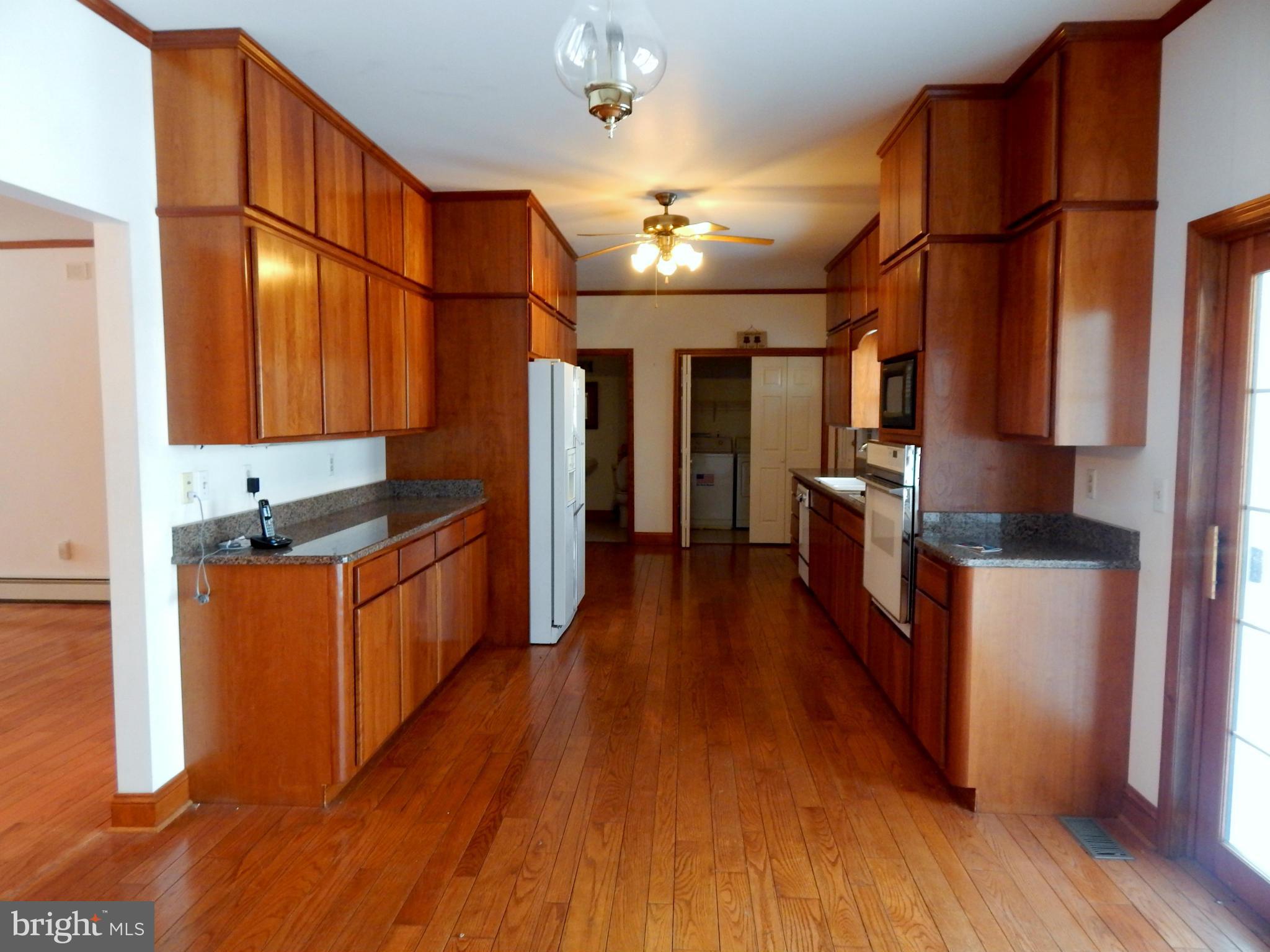3964 Street Road Street, MD 21154 - Photo 14 of 29 a kitchen with stainless steel appliances granite countertop a refrigerator a stove top oven a sink and dishwasher with wooden floor